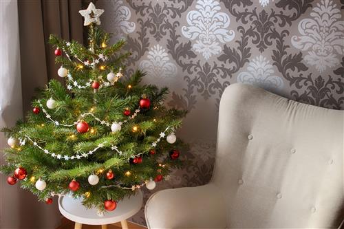 Beautiful christmas tree nearby armchair