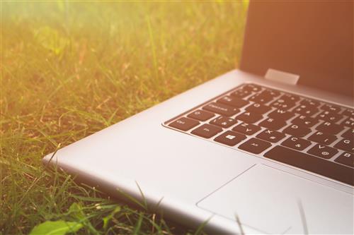 Laptop on grass in sunlight